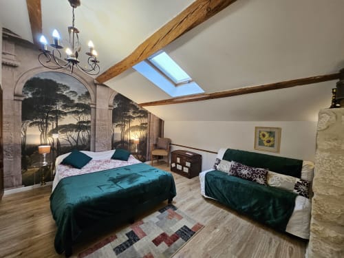 Geräumiges Schlafzimmer im Cottage Le Manoir Lacustre in Queyrac mit sichtbaren Balken, Dachfenster, Einzelbetten, Waldmalerei und Sitzbereich