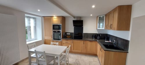 Cuisine et salle à manger modernes du Gîte Bambou au Mas de Trépeloup, Alès avec meubles en bois, plans de travail noirs