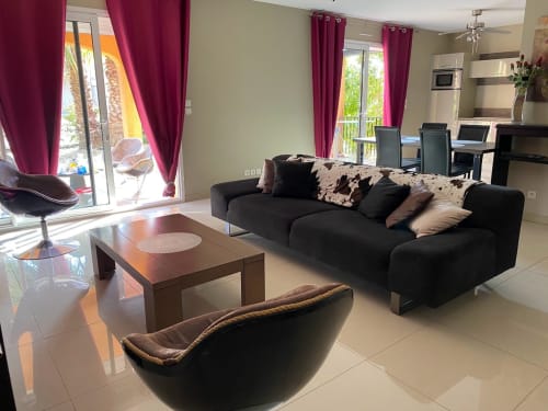 Vue sur Salon et cuisine toute équipée, fonctionnelle. Baies vitrées donnant sur la terrasse et jardin arboré indépendant, entièrement pour vous 