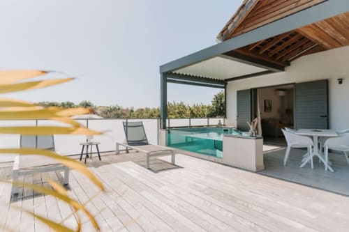 Terrasse contemporaine avec piscine turquoise, salon de détente et pergola en bois à l'Habitation l'SEO à Sainte-Anne, Guadeloupe