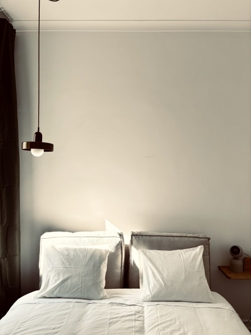 Minimalist bedroom with white bedding, two pillows, pendant light, and cream walls at Royal Prince Garden Apartments Lisboa