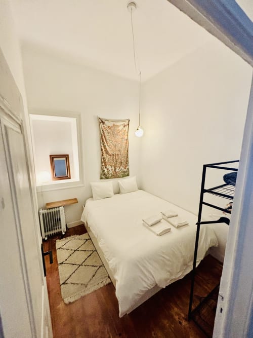 Cozy bedroom in Royal Prince Garden Apartments, Lisboa, with cream bedding, wooden floor, and minimalist décor