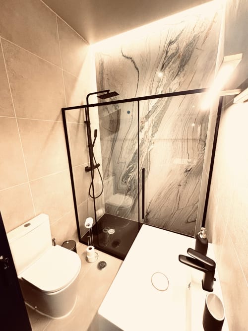 Modern bathroom in Royal Prince Garden Apartments, Lisboa, featuring walk-in shower with marble-effect tiles, white toilet,