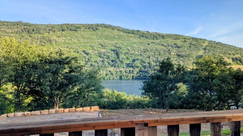 Terrazza in legno con vista sul fiume Ain circondato da colline boscose, Lodge La Cormière, Serrières-sur-Ain