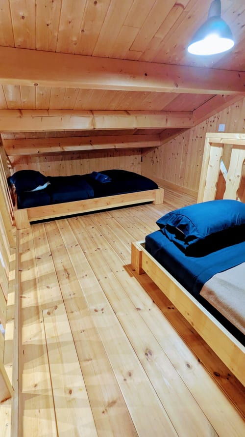 Accogliente camera da letto in lodge di legno presso Cabanes et lodges du Belvédère con due letti e biancheria blu a Serrières-sur-Ain