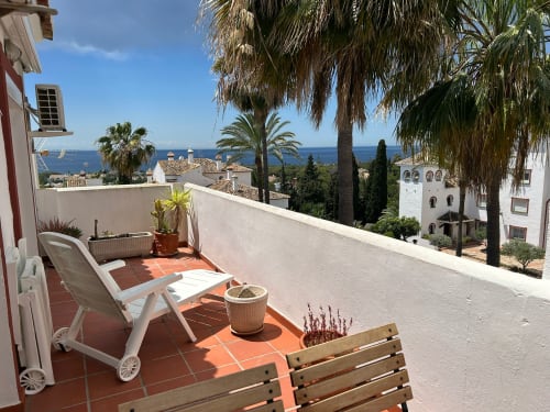 Terraza del apartamento SACORO en Marbella con vistas al mar, tumbonas y paisaje mediterráneo