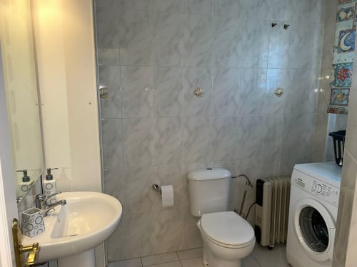 Baño moderno del apartamento SACORO en Marbella con ducha, inodoro, lavamanos y lavadora