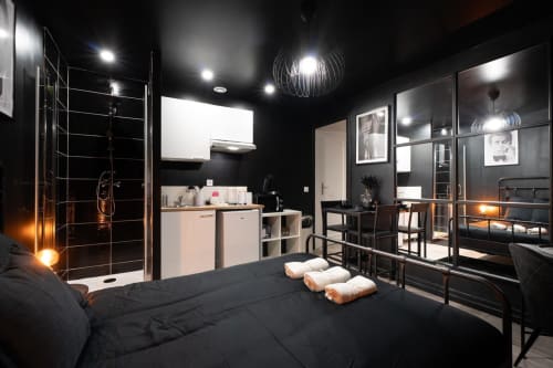 Luxury black bedroom at Wellkhome Bordeaux with en-suite bathroom, spa amenities, and modern furnishings