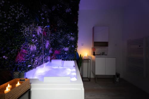 Luxurious spa bathroom at Wellkhome Bordeaux with illuminated jacuzzi, living wall, and ambient lighting