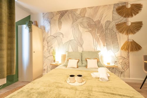 Modern bedroom at Wellkhome Bordeaux with botanical wall mural, yellow bedding, and green accents
