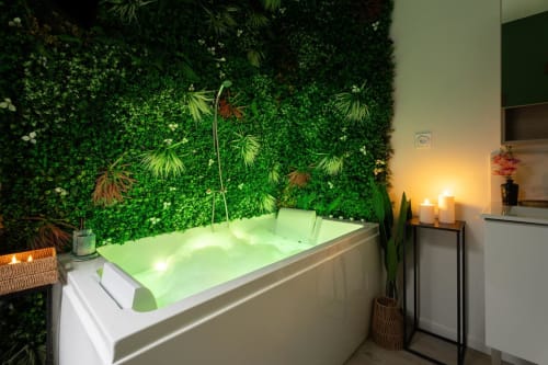 Luxurious bathtub with green lighting and living green wall in L'Amazone apartment at Wellkhome Bordeaux
