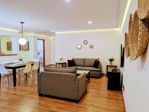 Sala de estar moderna del apartamento Casa Donceles en la Ciudad de México con sofás grises, mesa de comedor, piso de madera y diseño contemporáneo