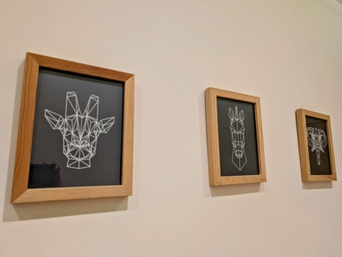 Tres dibujos geométricos enmarcados en la pared beige del hotel Casa Donceles en la Ciudad de México