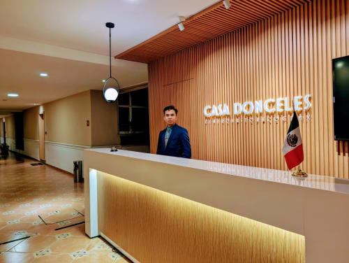 Recepción del hotel Casa Donceles en Ciudad de México con personal en chaqueta azul y bandera mexicana