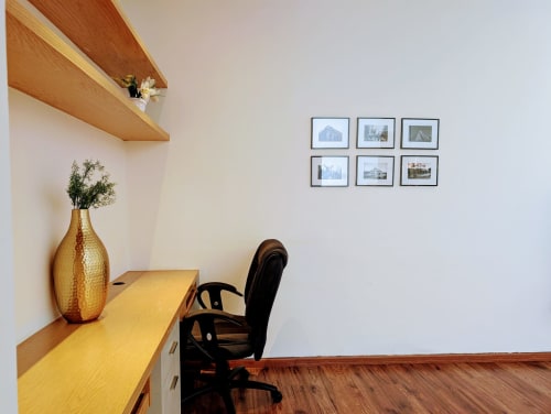 Espacio de trabajo moderno en Casa Donceles, apartamento de Ciudad de México con techo de vigas de madera, jarrón dorado y fotos enmarcadas