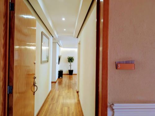 Pasillo moderno del apartamento 5 Casa Donceles en Ciudad de México, con puertas de madera, piso laminado y techo contemporáneo
