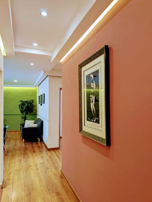 Pasillo moderno del departamento Casa Donceles en Ciudad de México con paredes coral, cuadros enmarcados, piso de madera y estilo contemporáneo