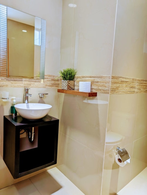 Baño moderno en Casa Donceles en México con lavabo blanco, mueble negro, ducha tipo lluvia, azulejos color crema y