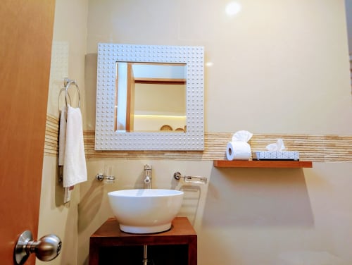 Mueble de baño moderno con lavabo blanco y marco de madera en el hotel Casa Donceles de Ciudad de México