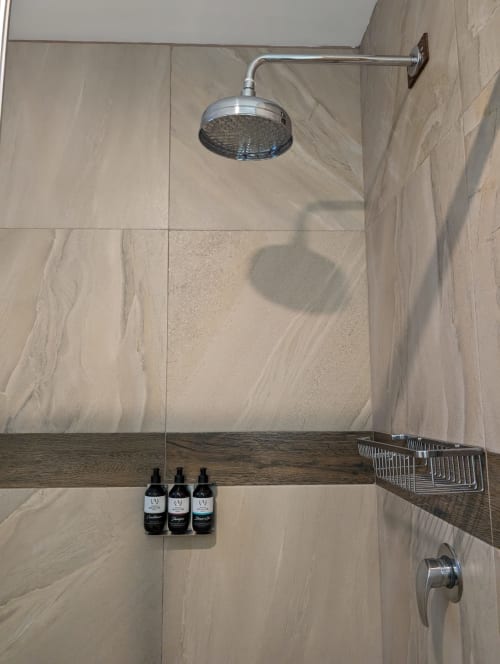 Baño moderno en el penthouse Casa Donceles con ducha tipo lluvia, azulejos de mármol y amenities en Ciudad de México