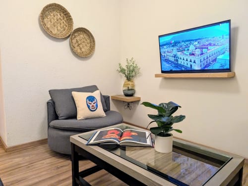Sala de estar moderna en penthouse Casa Donceles de México con sofá gris, TV inteligente con vistas de la ciudad y diseño contemporáneo