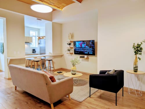 Sala moderna en penthouse Casa Donceles, Ciudad de México, con sofá beige, sillón negro, TV inteligente montada y espacio abierto