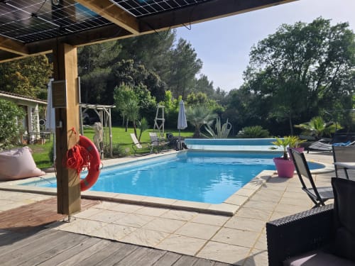 Espace piscine luxe au Domaine à l'Aise à Saint-Pargoire avec transats, pergola et jardins verdoyants