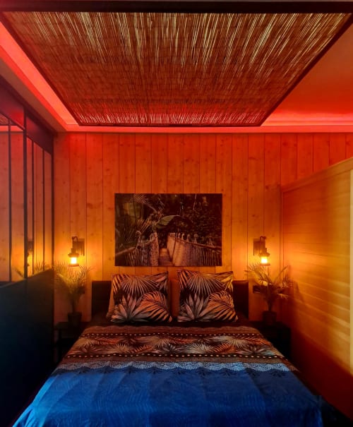 Modernes Schlafzimmer im Ospaloft Arras mit rot-orangem Umgebungslicht, Queen-Size-Bett mit gemusterten Kissen und zeitgenössischer Einrichtung