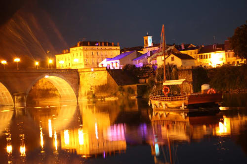 Charmante ville fluviale historique illuminée la nuit avec pont en pierre et architecture traditionnelle près de Saint-Germain