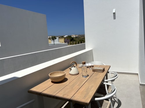 Terraço moderno da villa Star Host Casa Tonel em Bordeira com mesa de madeira, vistas rurais e luminosidade mediterrânea