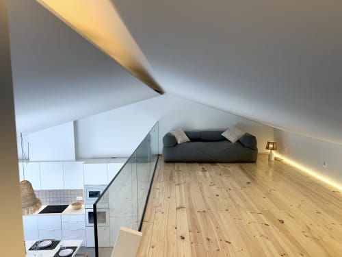Quarto de loft moderno com sofá escuro, assoalho em madeira e kitchenette na villa Casa Tonel, Bordeira