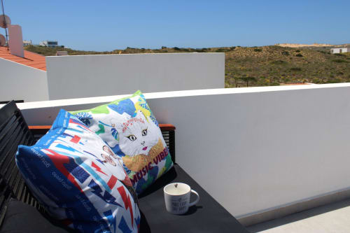 Almofada e caneca coloridas com gato no terraço da cobertura da Vila Casa Tonel, Bordeira Portugal com vistas das colinas costeiras