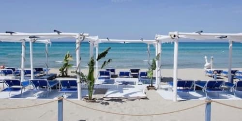 Club spiaggia della Masseria Picca Picca con lettini blu, pergolato bianco e mare turchese a Morciano di Leuca
