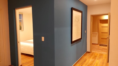 Pasillo del apartamento Casa Donceles con acceso a dormitorio, cuadros enmarcados, pisos de madera y pared azul destacada en Ciudad de México