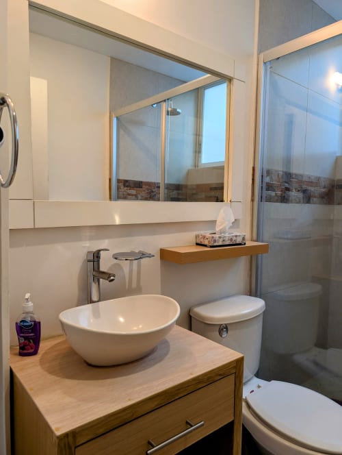 Baño moderno en Casa Donceles, Ciudad de México con lavabo tipo recipiente, mueble de madera, inodoro y cabina de ducha
