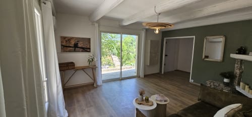 Salon ouvert vue sur la nature murs vert et cheminée d'angle Nuits d'Audace