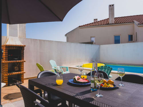 Terraço de refeições ao ar livre com vista para piscina privada na villa Fabulous Beach House em Bombarral, Portugal