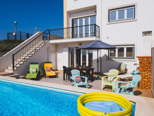 Moradia moderna com piscina privada, área de estar e guarda-sol azul com vista para o Atlântico no Baleal, Portugal