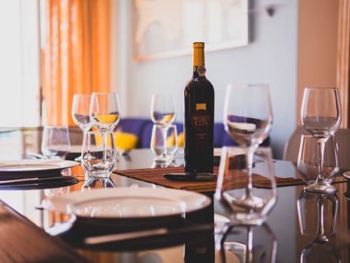 Elegante mesa de jantar com garrafa de vinho, taças e talheres na villa Fabulous Beach House em Bombarral, Portugal