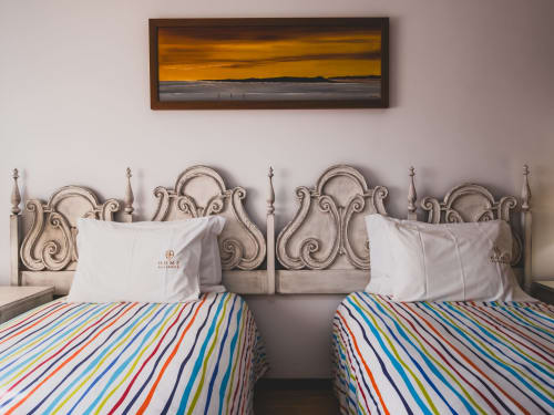 Two twin beds with colorful striped bedding at Home Alliance villa in Bombarral, Portugal, with decorative headboards and