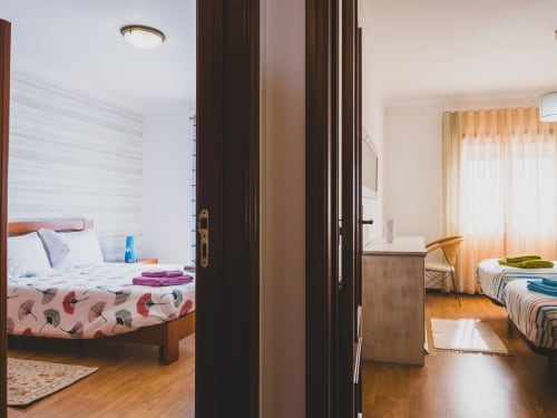 Open doorway connecting two bright bedrooms in Baleal Beach Holiday Villa, Portuguese villa with wooden floors and sea views