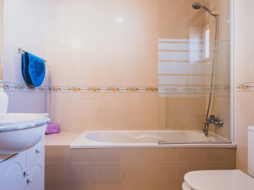 Bathroom at Baleal Beach Holiday Villa in Bombarral with bathtub, shower enclosure, and sea view access