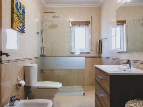 Banheiro moderno na villa Baleal Sunset Residence com duche, dupla bancada, sanitário e piso em azulejo