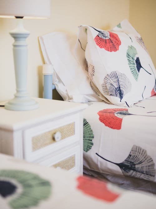 Quarto da villa Baleal Sunset Residence com almofadas estampadas, criado branco e decoração litorânea na Home Alliance