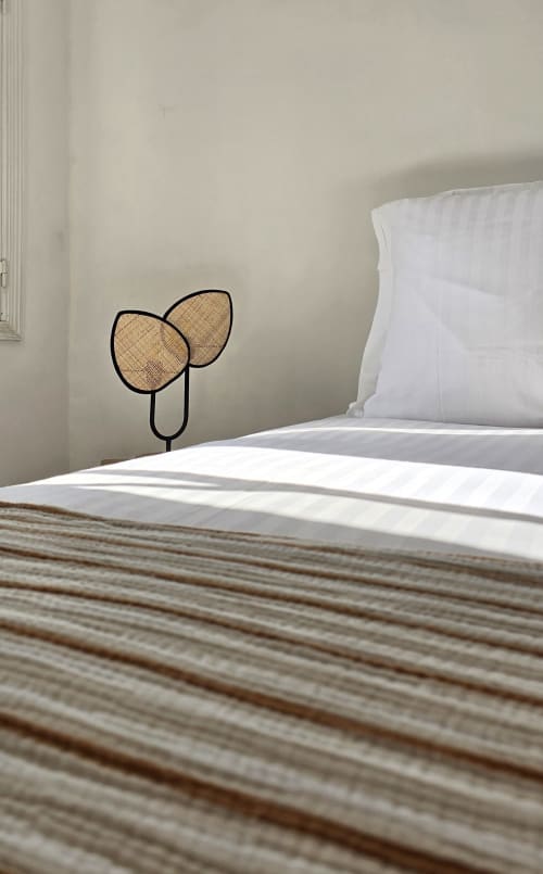 Minimalist bedroom at Hôtel De La Fontaine in Nice with white bedding and decorative leaf sculpture