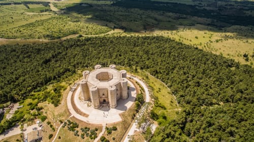 Veduta aerea di Castel del Monte circondata da boschi verdeggianti e campagna vicino ad Andria, Italia
