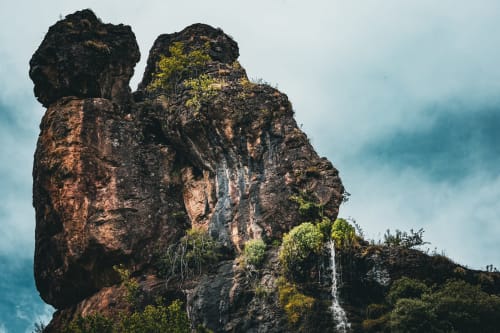 Formación rocosa dramática cubierta de musgo y vegetación en Cuevas de Viñayo, ubicación de Casa Rural Sensaciones en España