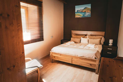 Dormitorio acogedor de la villa Casa Rural Sensaciones con muebles de madera, cuadros de montaña y luz natural