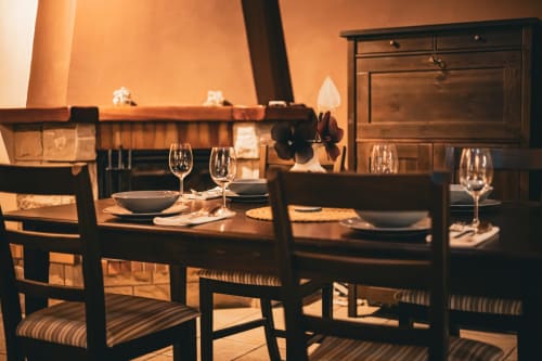 Elegante comedor de Casa Rural Sensaciones con mesa iluminada por velas, copas de vino y vistas a las montañas en Carrocera