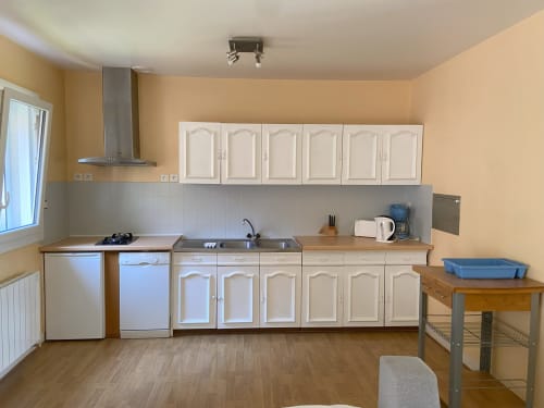 Cuisine moderne aux placards crème, électroménagers inox et plan de travail en bois - appartement à Bracieux